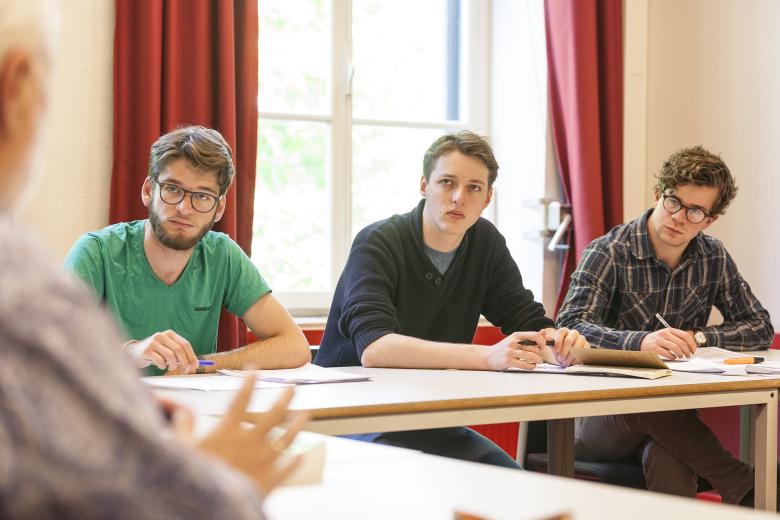 Students listening to a speaker in a classroom setting